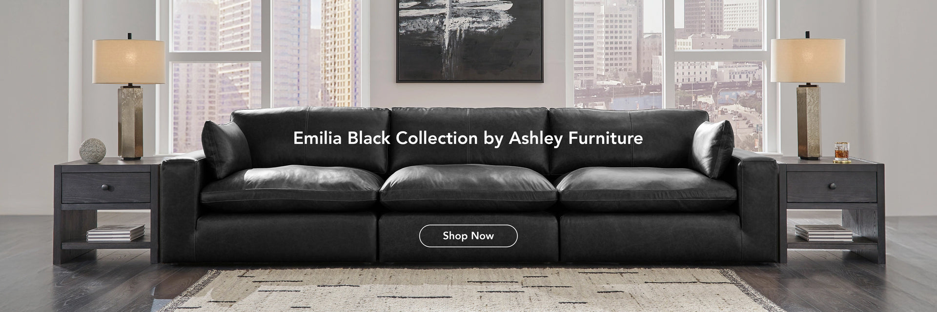 Black sofa with 'Emilia Black Collection by Ashley Furniture' branding in a living room setting.