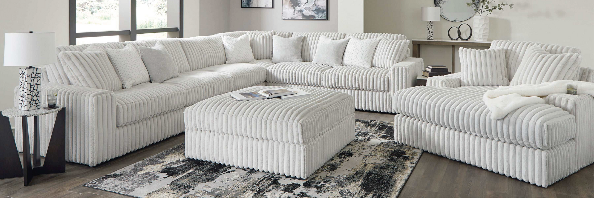 Living room with a large striped sectional sofa and ottoman.