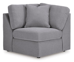Contemporary gray modular sectional sofa arranged in a living room setting with a storage console featuring an audio system.