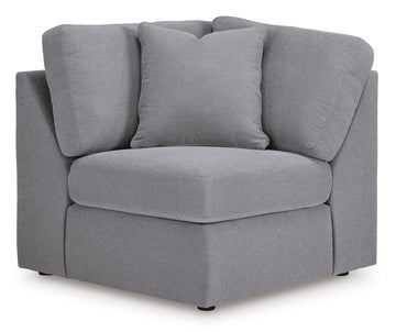 Contemporary gray modular sectional sofa arranged in a living room setting with a storage console featuring an audio system.